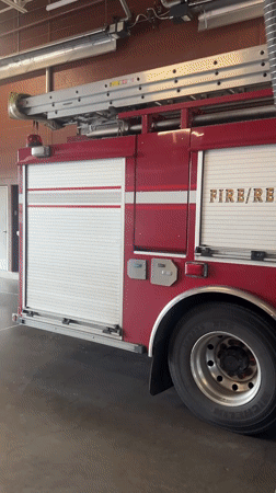 Fire truck parked in Surrey station, hose attached and ready
