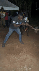 Men dig during nighttime community gathering in Eziudo, Nigeria
