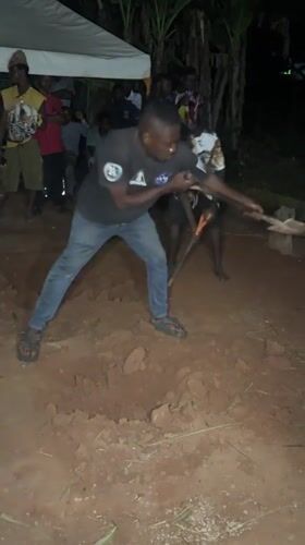 Men dig during nighttime community gathering in Eziudo, Nigeria