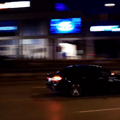 Nighttime traffic captured near McDonald's includes speeding vehicles, motorcyclist