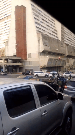 Evening traffic flows through Caracas streets amid urban skyline
