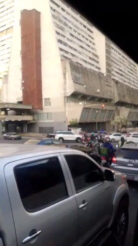 Evening traffic flows through Caracas streets amid urban skyline