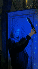 Person tests color-changing light device in nighttime Moscow