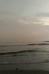 Dusk at a Lhokseumawe beach, with a soccer match on the side
