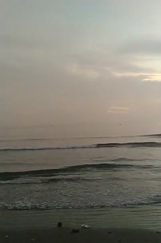 Dusk at a Lhokseumawe beach, with a soccer match on the side
