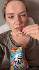 Woman enjoys crab crisps, relaxes in Dreiliņi apartment