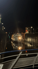 River cruise ship navigates a lit canal lock at night in Dubna