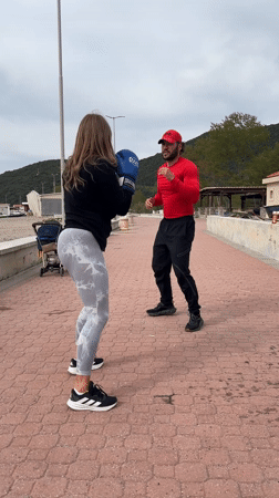 Woman practices boxing with coach on Montenegro coastal path
