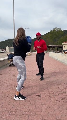 Woman practices boxing with coach on Montenegro coastal path