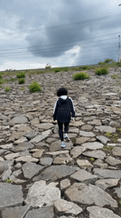 Runner climbs rocky slope in Kryvyi Rih under cloudy skies