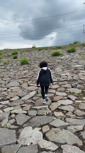 Runner climbs rocky slope in Kryvyi Rih under cloudy skies