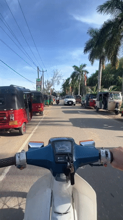 Motorcyclist travels through Sri Lankan towns during Buddhist festival celebration