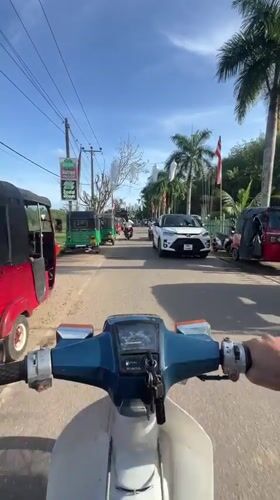 Motorcyclist travels through Sri Lankan towns during Buddhist festival celebration