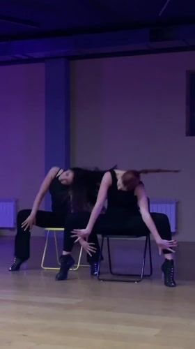 Dance duo rehearses synchronized chair routine in Balashikha studio