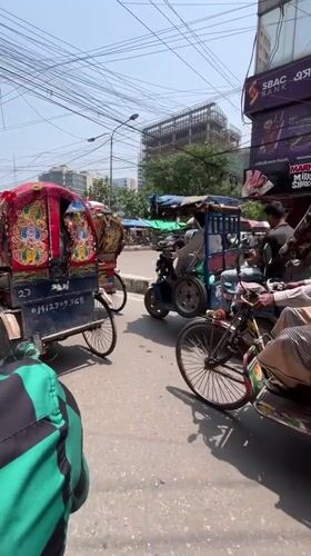 Morning street commerce bustles in Dhaka with rickshaws, vendors