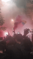 Night crowd gathers with flags, smoke in Buenos Aires