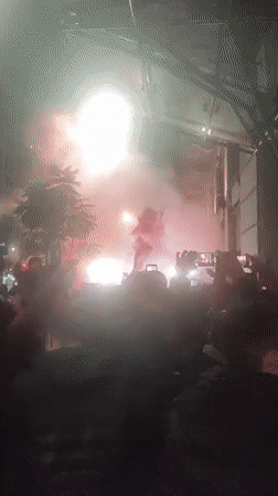 Night crowd gathers with flags, smoke in Buenos Aires