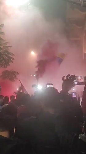 Night crowd gathers with flags, smoke in Buenos Aires