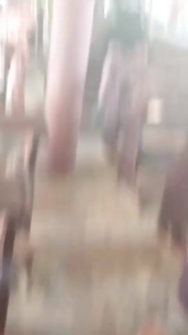 The video shows the interior of a building. There are rows of empty wooden pews, colorful stained-glass windows, and a red carpet. People can be seen in the background. The camera movement is shaky.
