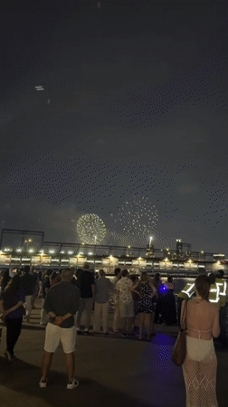 July 4th fireworks over a New York waterfront crowd
