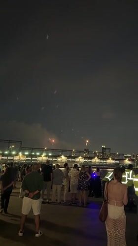 July 4th fireworks over a New York waterfront crowd