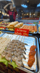 Street food vendor serves grilled skewers at Pattaya night market