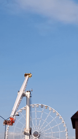 Amusement ride swings high over Szczecin on a clear day