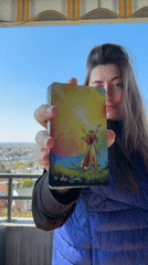 Woman displays tarot card from balcony in Waiblingen