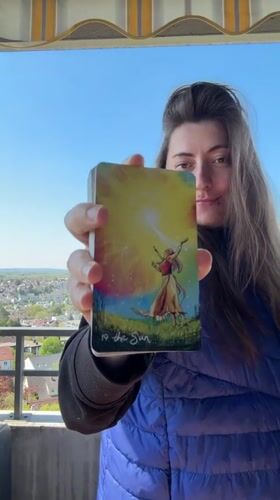 Woman displays tarot card from balcony in Waiblingen