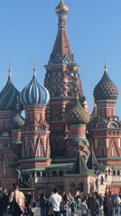 Tourists document Red Square landmarks under clear Moscow skies