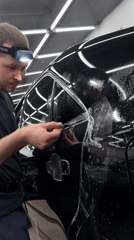 Man installs protective film on vehicle in early morning