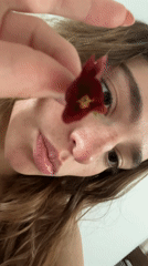 Woman places red flower in mouth in Mexico