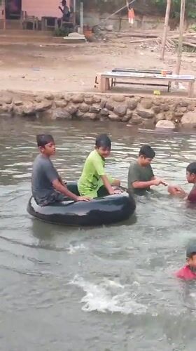 Children play in Saweuk river amid rural Indonesian village life