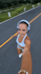 Woman films herself jogging on road in Chalong, Thailand