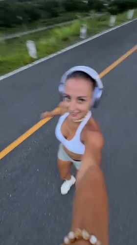 Woman films herself jogging on road in Chalong, Thailand