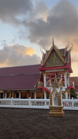 Choeng Thale temple at golden hour, monk passing by
