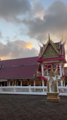 Choeng Thale temple at golden hour, monk passing by