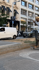 Skateboarder performs tricks across Barcelona streets during sunny afternoon