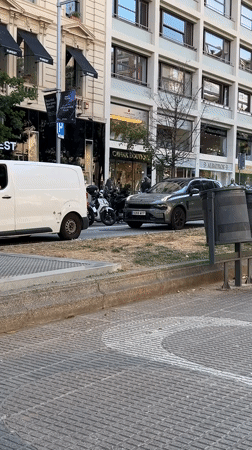 Skateboarder performs tricks across Barcelona streets during sunny afternoon