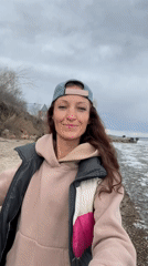 Woman visits Volga River shoreline in Ulyanovsk under cloudy skies