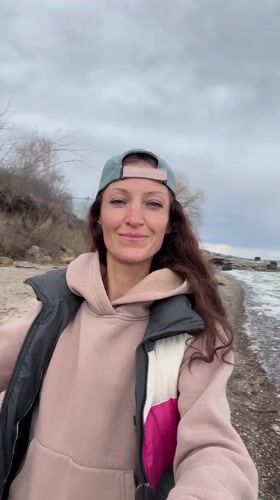 Woman visits Volga River shoreline in Ulyanovsk under cloudy skies
