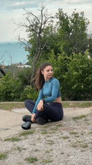 Woman interacts with gray cat near Varna concrete wall