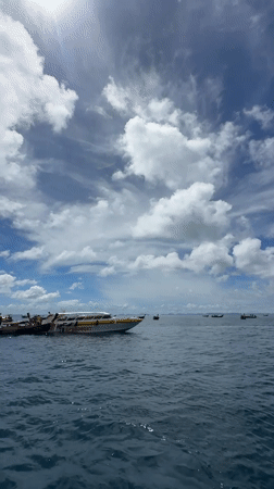 Boats on the water at Haad Yao's rocky coastline