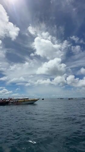 Boats on the water at Haad Yao's rocky coastline