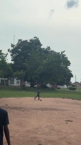 Two play football on dirt field in Ihiagwa, Nigeria