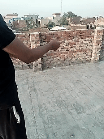 Children fly kites on rooftops in Dera Chahal, Pakistan