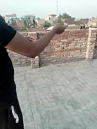 Children fly kites on rooftops in Dera Chahal, Pakistan