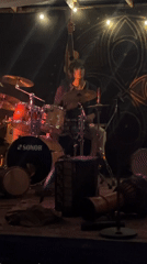 Live band performs on a moody, instrument-packed stage