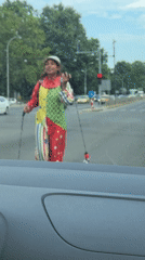 Clown at a Varna crosswalk, full costume, broad daylight.