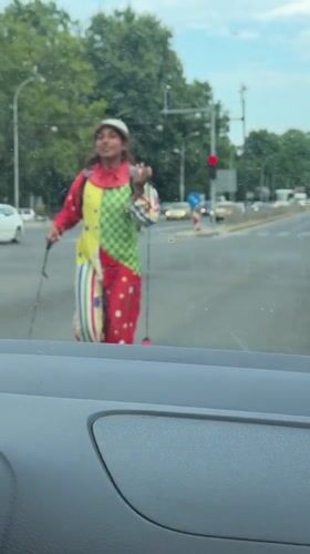 Clown at a Varna crosswalk, full costume, broad daylight.